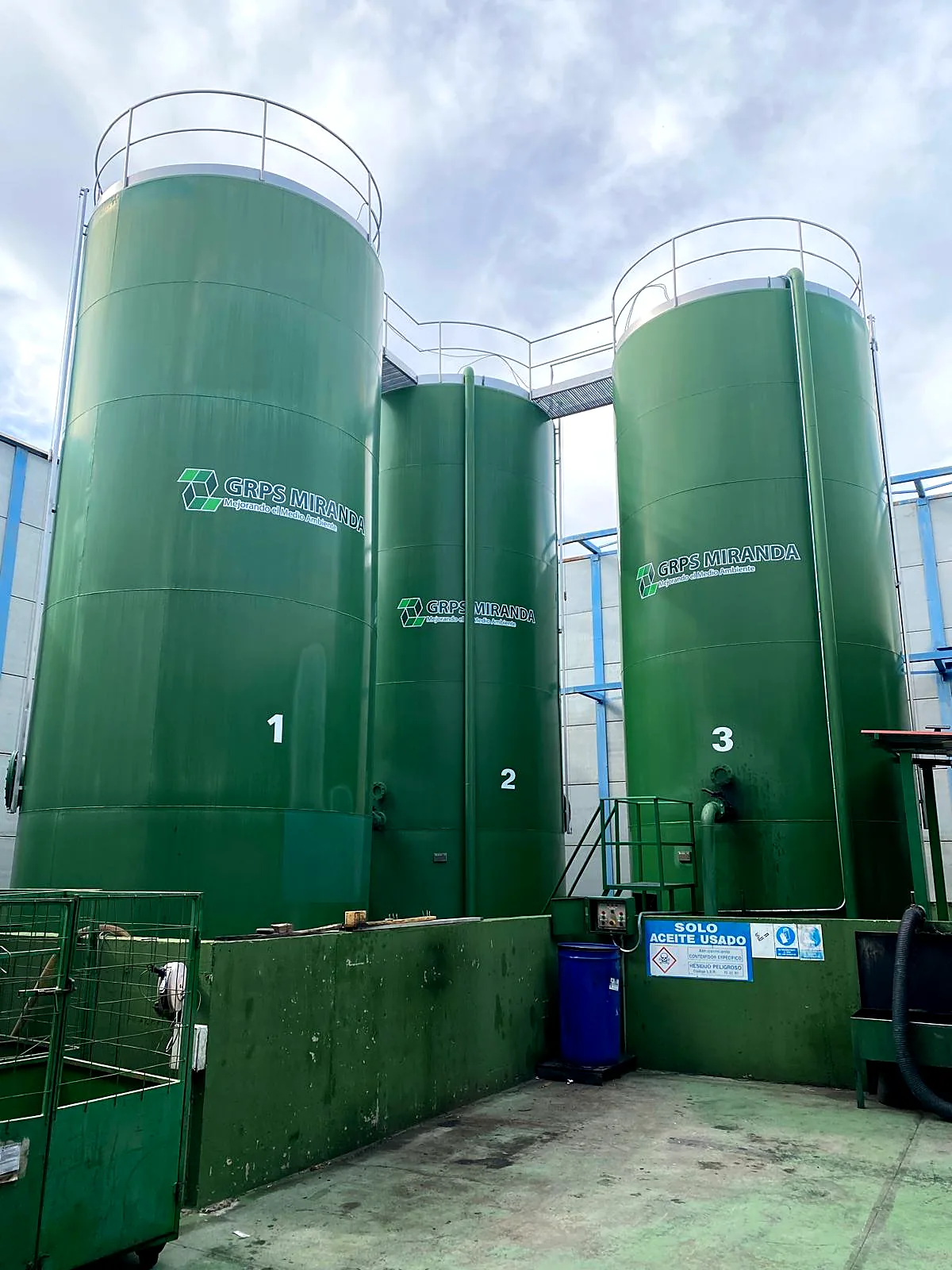 Tres depósitos verdes de almacenamiento de aceite usado