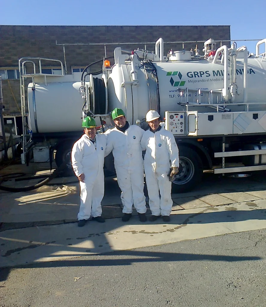 Operarios de GRPS Miranda con trajes de protección junto a los camiones