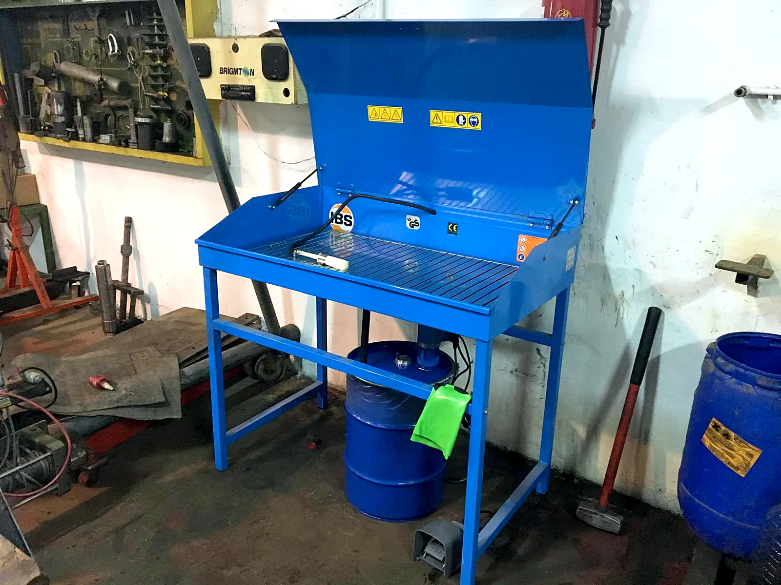 Máquina lavapiezas azul en un taller mecánico
