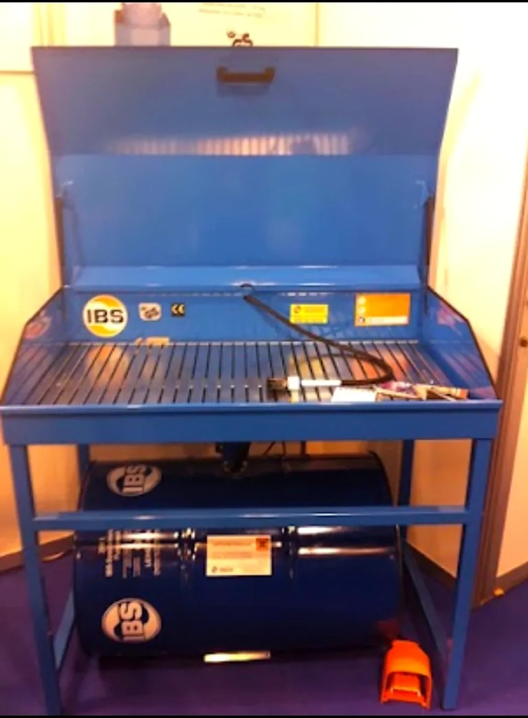 Máquina lavapiezas azul con su depósito